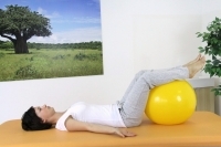 Straightening the spine while lying on the back with the legs up